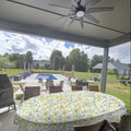 Oval lemon floral oilcloth tablecloth on outdoor patio table by pool, Premier Table Linens